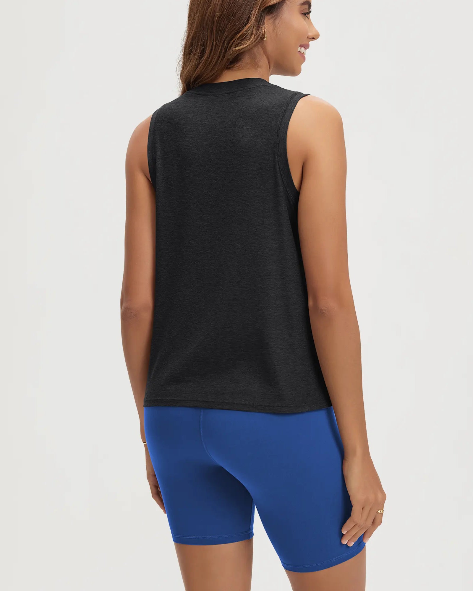 ODODOS Stratum Women's Performance Tank in black, paired with blue workout shorts.