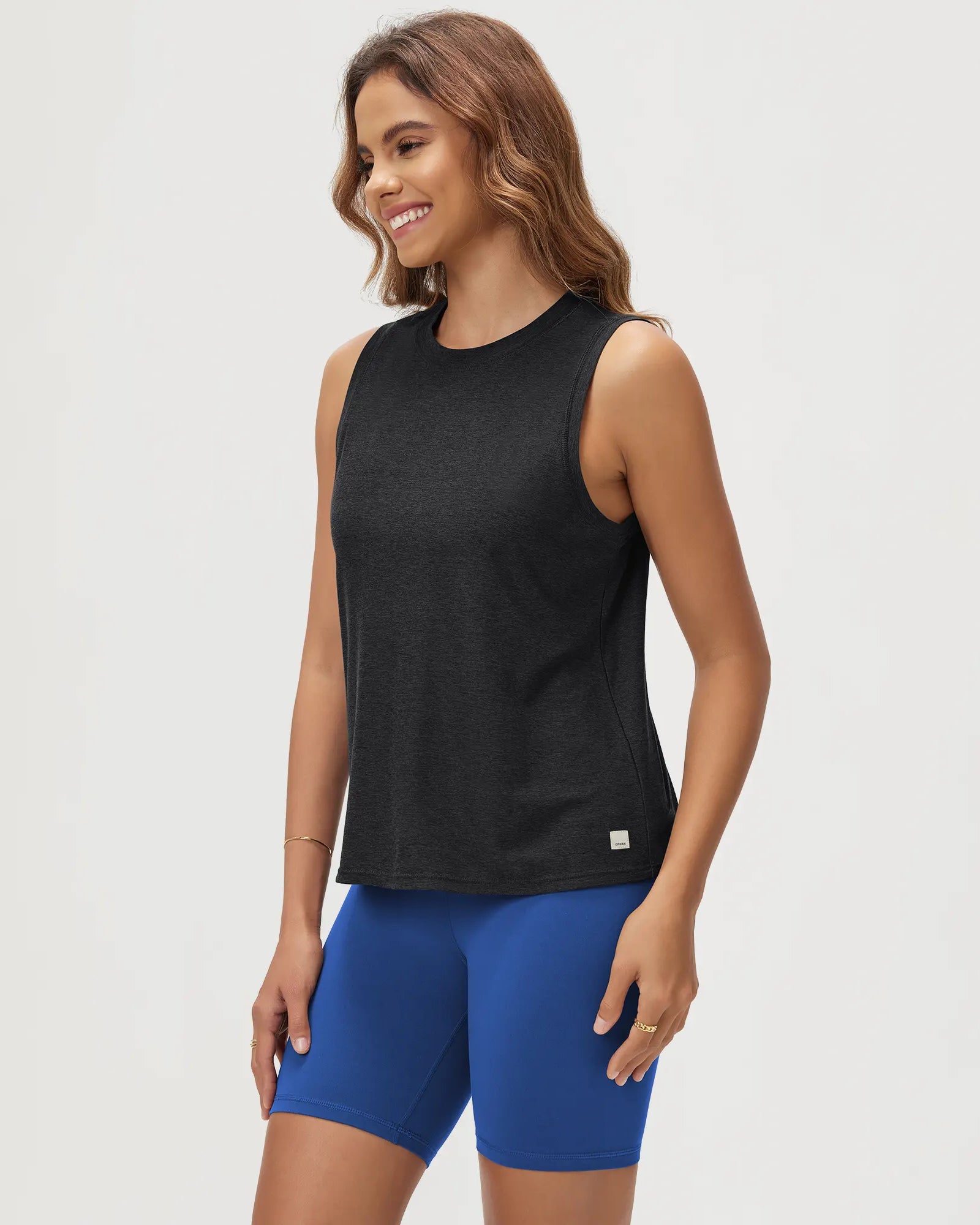 ODODOS Stratum Women's Performance Tank in black with blue workout wear shorts.