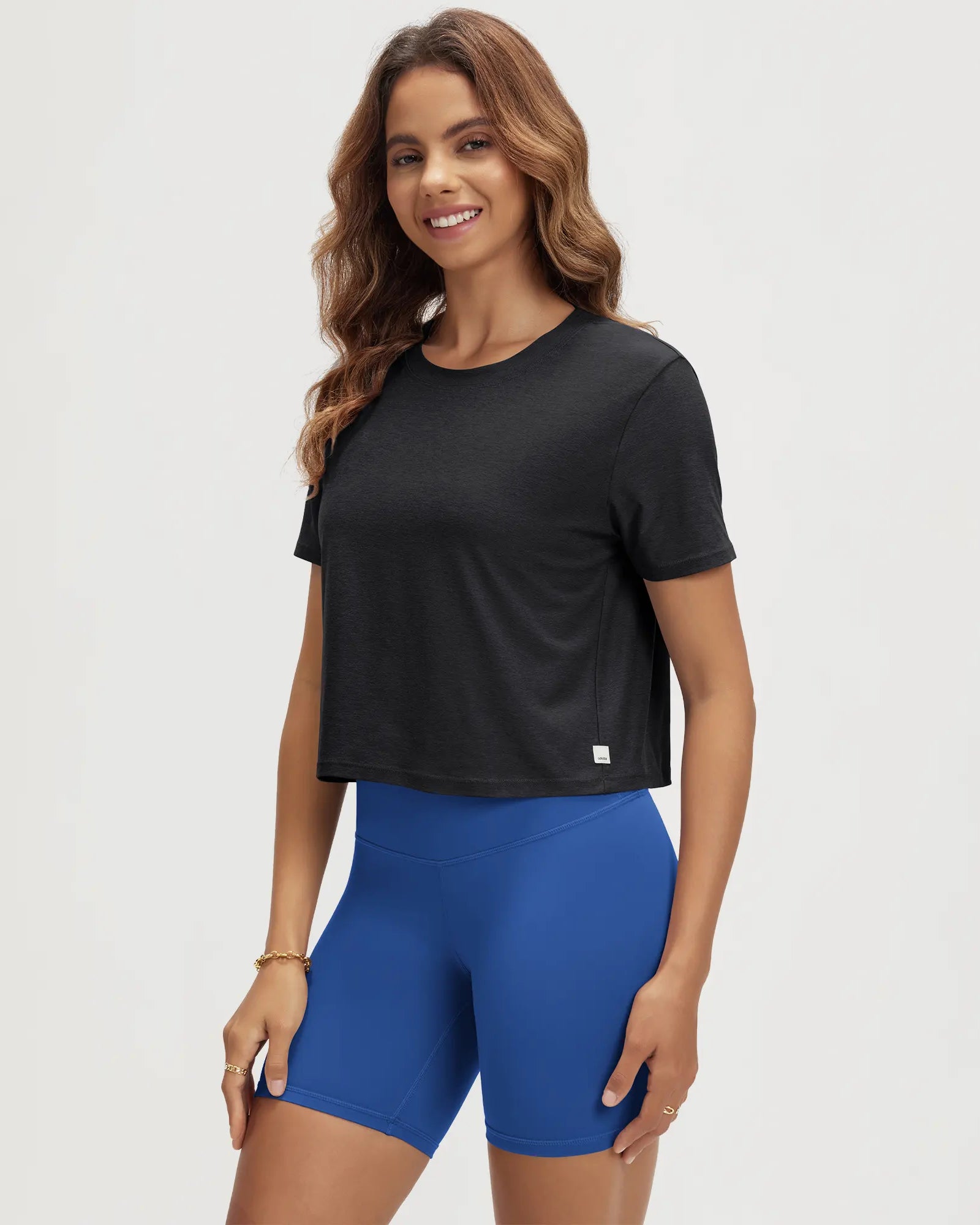 ODODOS Stratum Women's Performance Cropped Tee in black with athletic fit shorts.