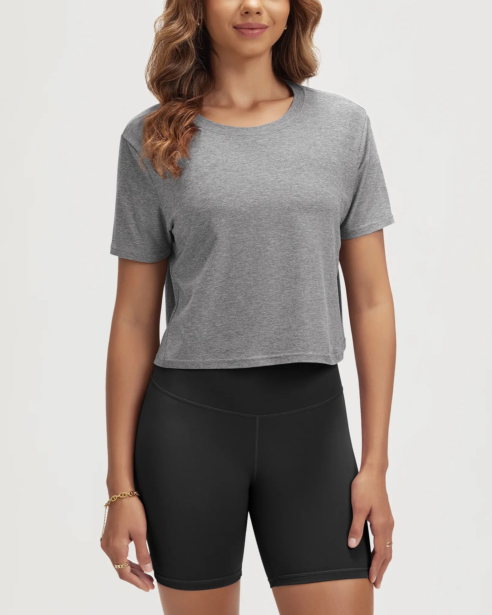 ODODOS Stratum Women's Performance Cropped Tee in gray, paired with athletic fit shorts.