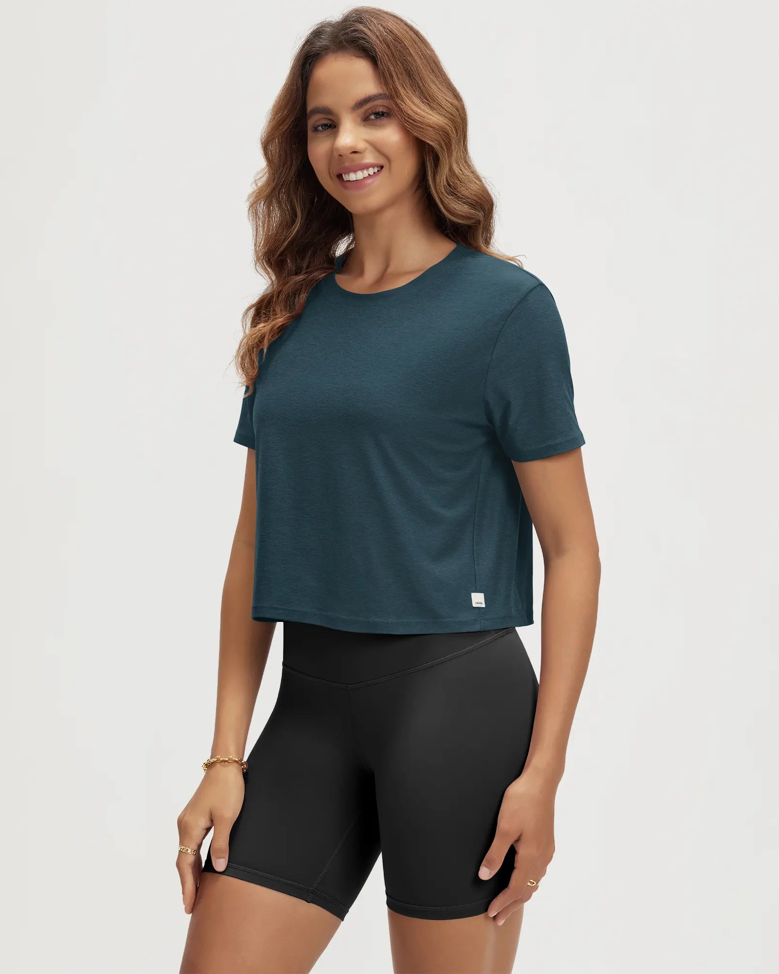ODODOS Stratum Women's Performance Cropped Tee in teal, breathable soft fabric for workout wear.