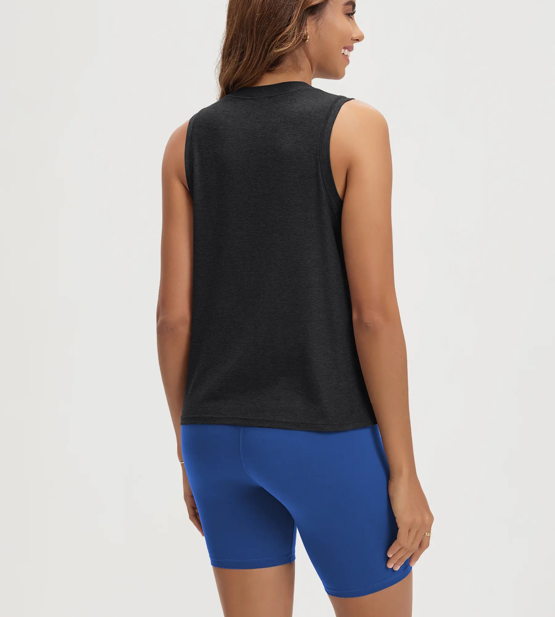 ODODOS Stratum Women's Performance Tank in black, paired with blue workout shorts.