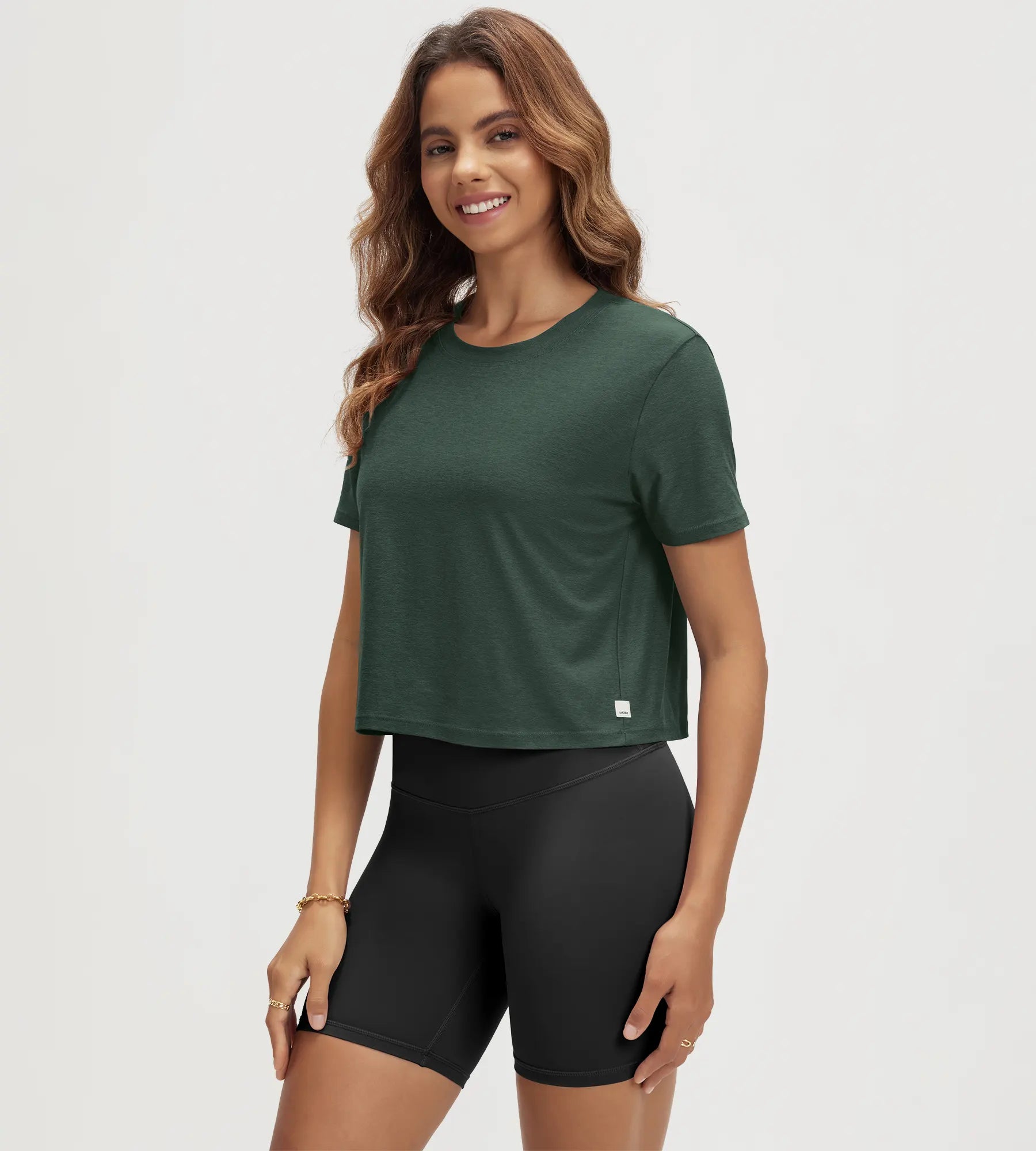 ODODOS Stratum Women's Performance Cropped Tee in green, ideal for workout wear.