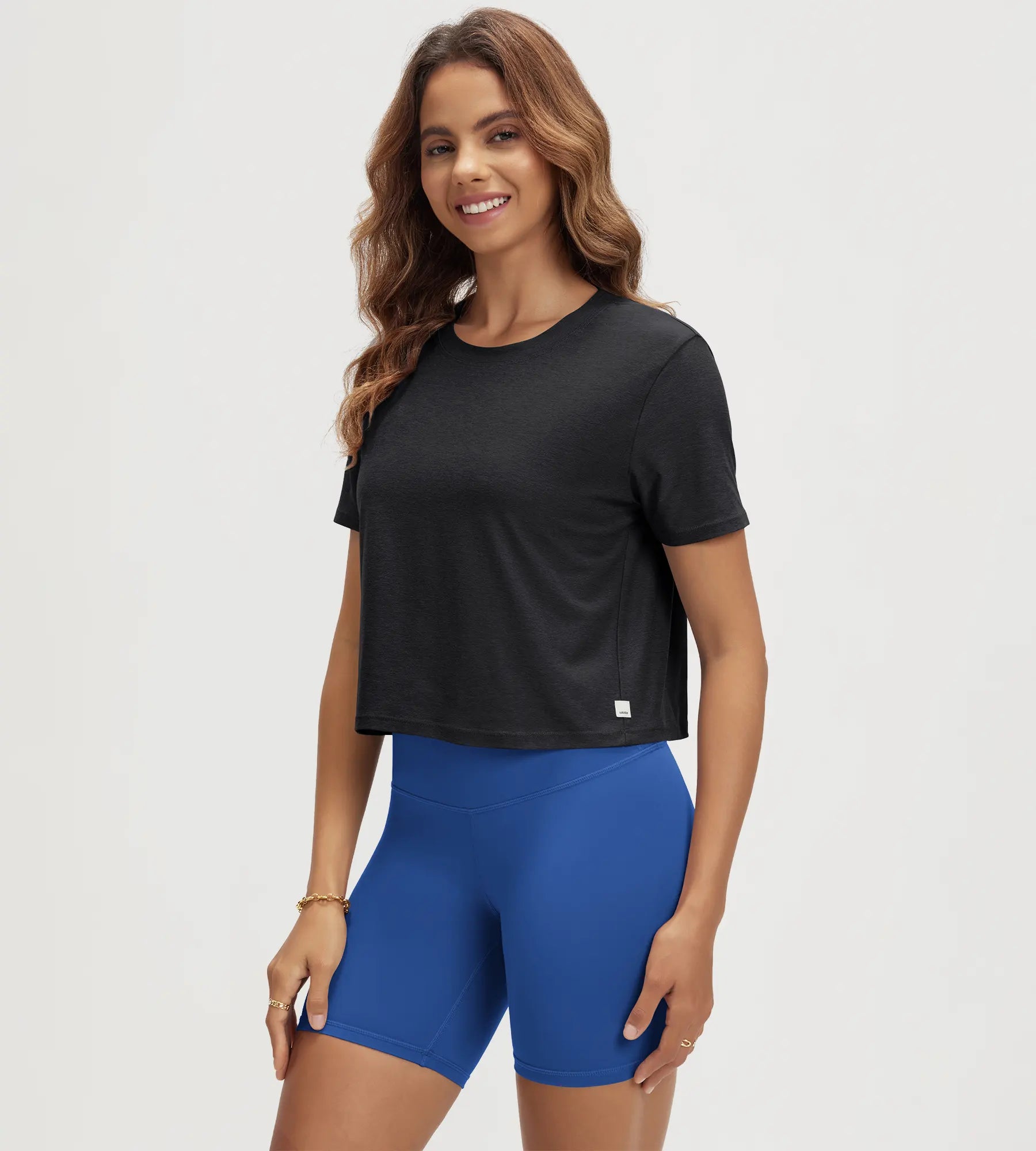ODODOS Stratum Women's Performance Cropped Tee in black with athletic fit shorts.