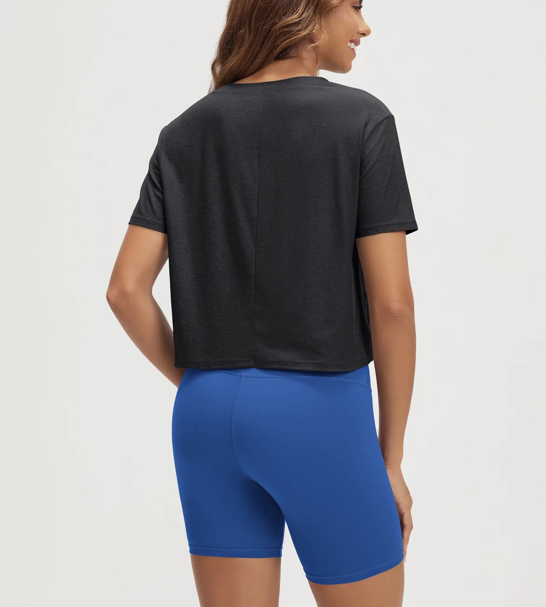 ODODOS Stratum cropped tee in black paired with blue workout shorts, showcasing soft fabric and athletic fit.