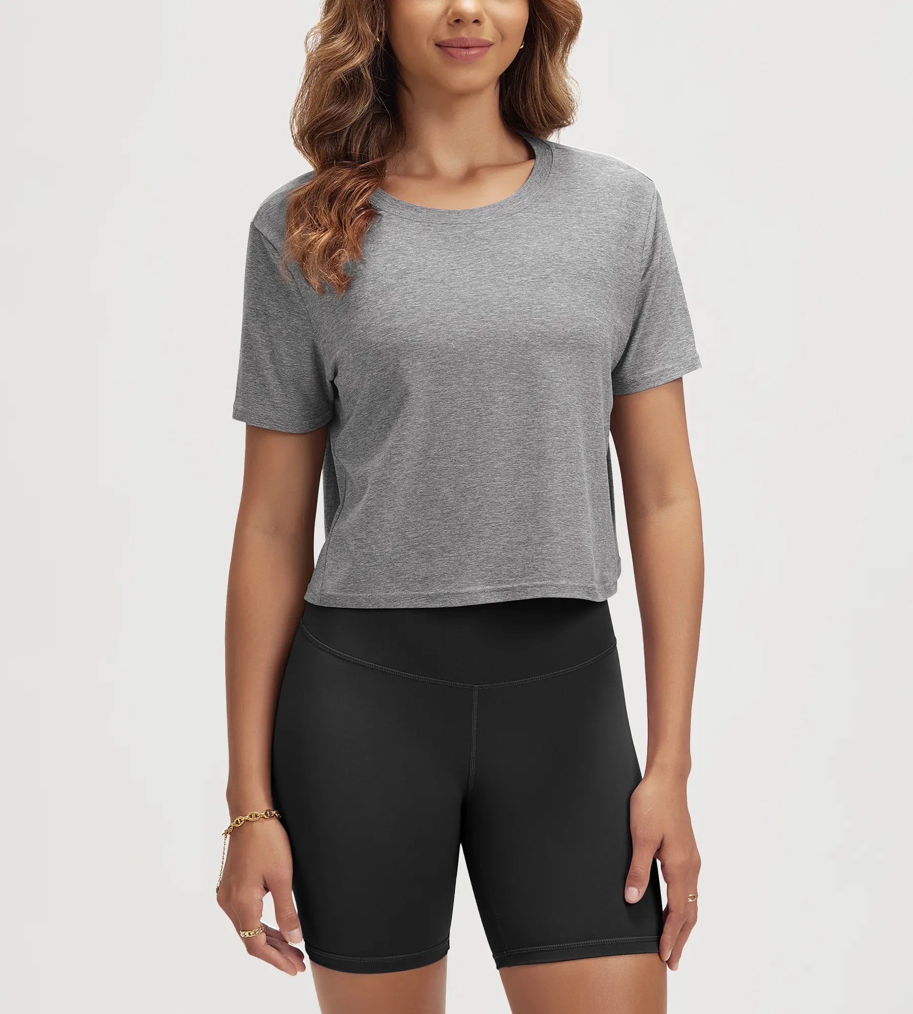 ODODOS Stratum Women's Performance Cropped Tee in gray, paired with athletic fit shorts.