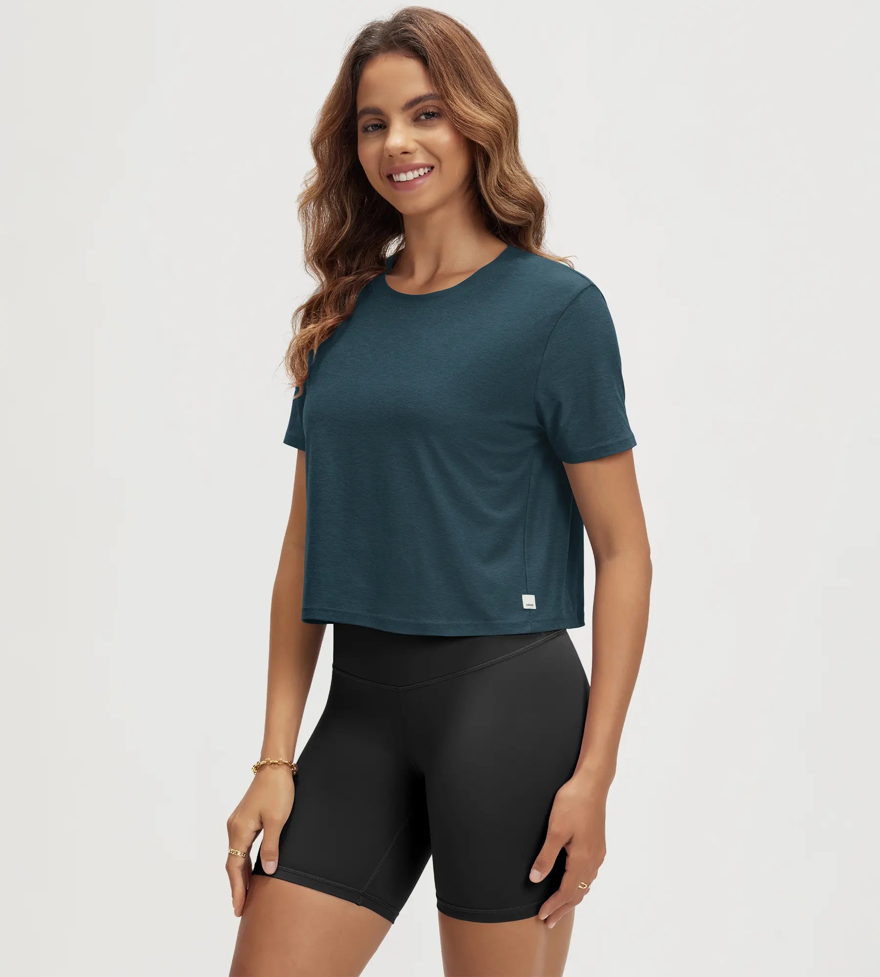 ODODOS Stratum Women's Performance Cropped Tee in teal, breathable soft fabric for workout wear.